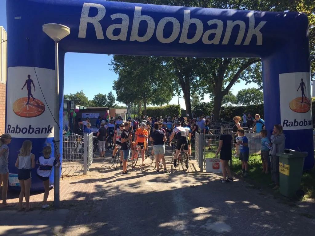 Fietsers passeren de finishboog van het eerste Team Wybe Wielerfeest in 2016